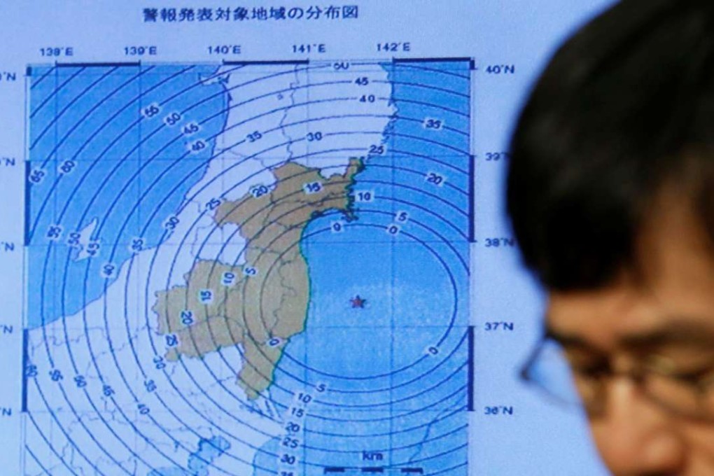 Japan Meteorological Agency's earthquake and volcano observations division director Koji Nakamura addresses a news conference next to the map showing an earthquake epicentre. Photo: Reuters