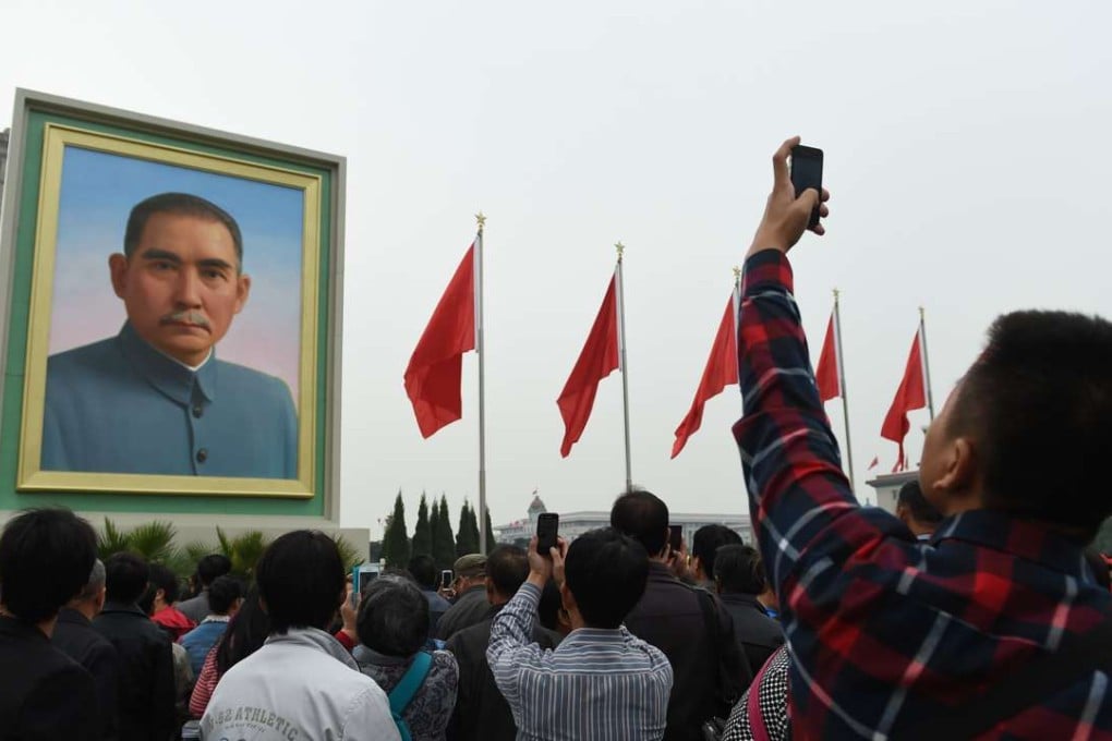 A man takes photos of a portrait of Sun Yat-sen in Beijing's Tiananmen Square. Photo: AFP
