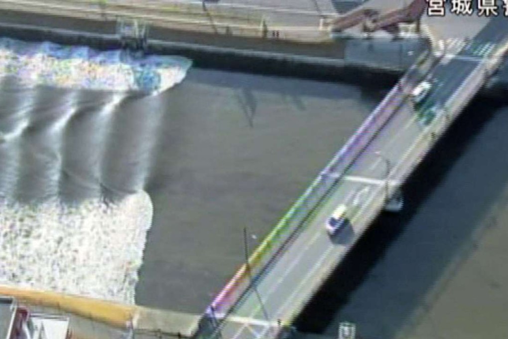 A tidal surge is seen in Sunaoshi River after tsunami advisories were issued following an earthquake in Tagajo, Miyagi prefecture, Japan. Photo: Kyodo