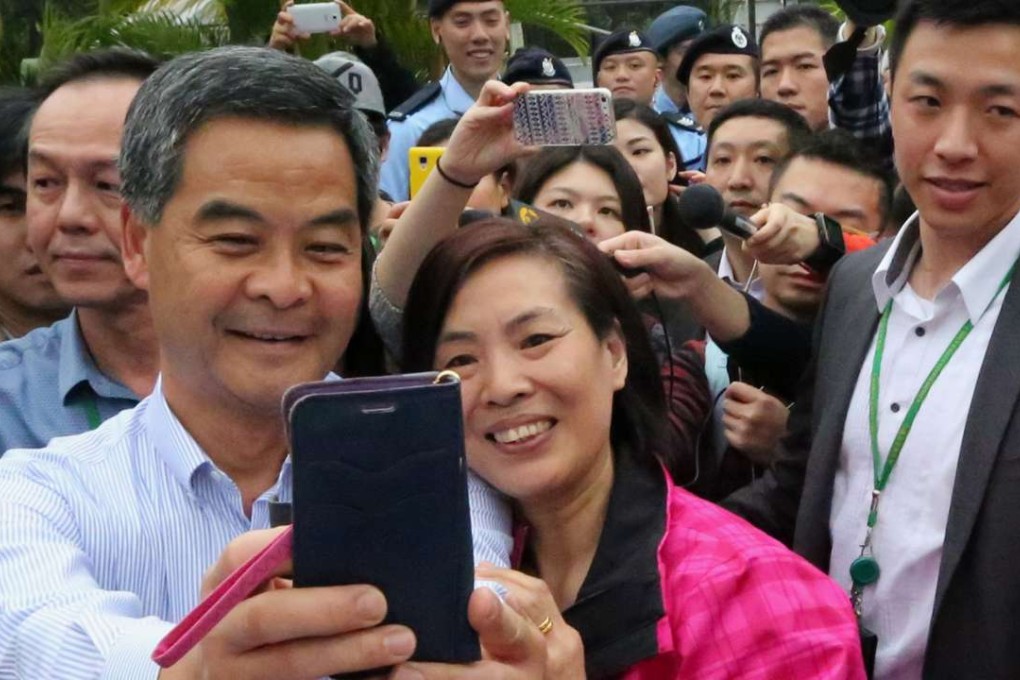 A visitor poses with Chief Executive Leung Chun-ying for a picture during the Government House annual open day in Central. Photo: Felix Wong