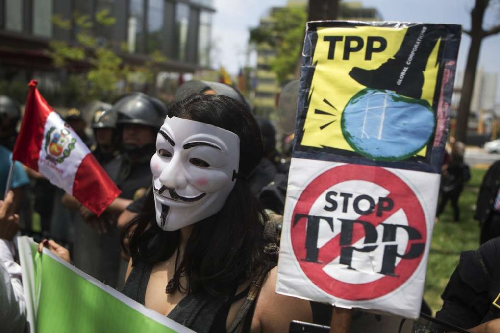 A protester holds signs against the Trans Pacific Partnership (TPP) during a rally in Lima, Peru, on Friday. As leaders of the Asia-Pacific Economic Cooperation (APEC) met in Lima, dozens of people rallied against the TPP, a proposed trade agreement among twelve Pacific Rim countries, excluding China. Photo: AP