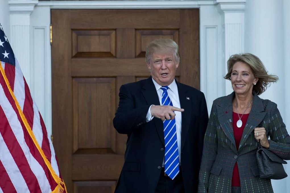 US President-elect Donald Trump with Betsy DeVos, who he intends to nominate as education secretary, after their meeting at the Trump International Golf Club in New Jersey on November 18. Photo: AFP