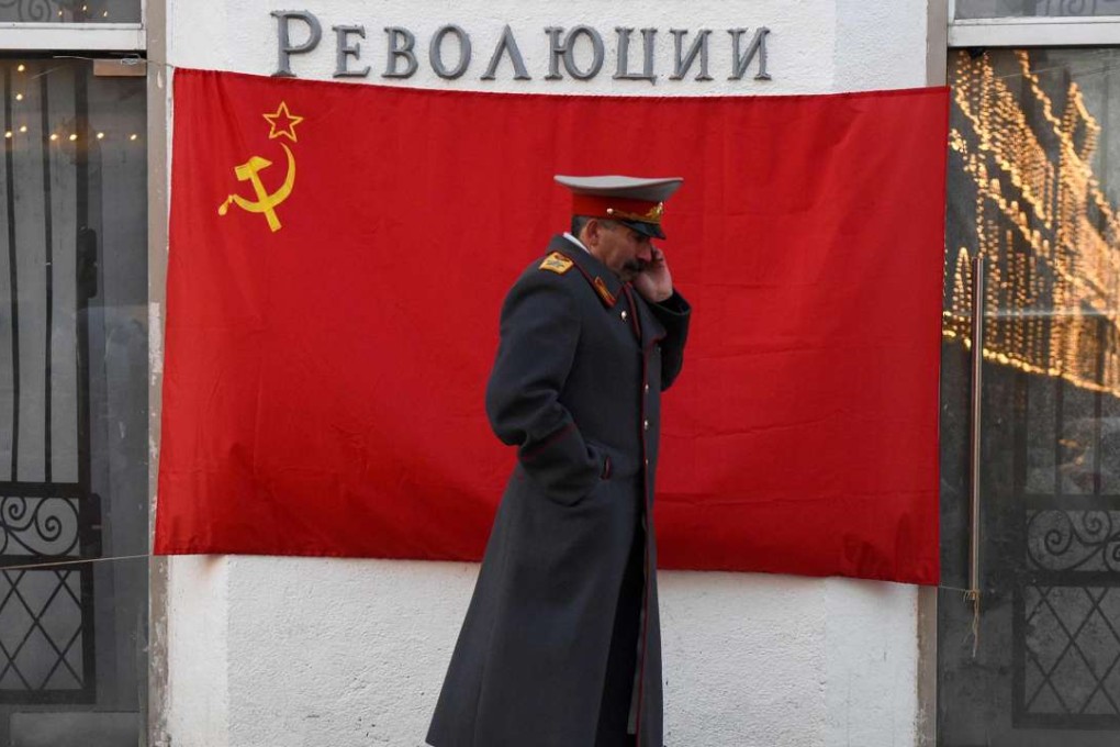An impersonator of Soviet leader Joseph Stalin walks past a hammer-and-sickle red flag in central Moscow. Photo: AFP