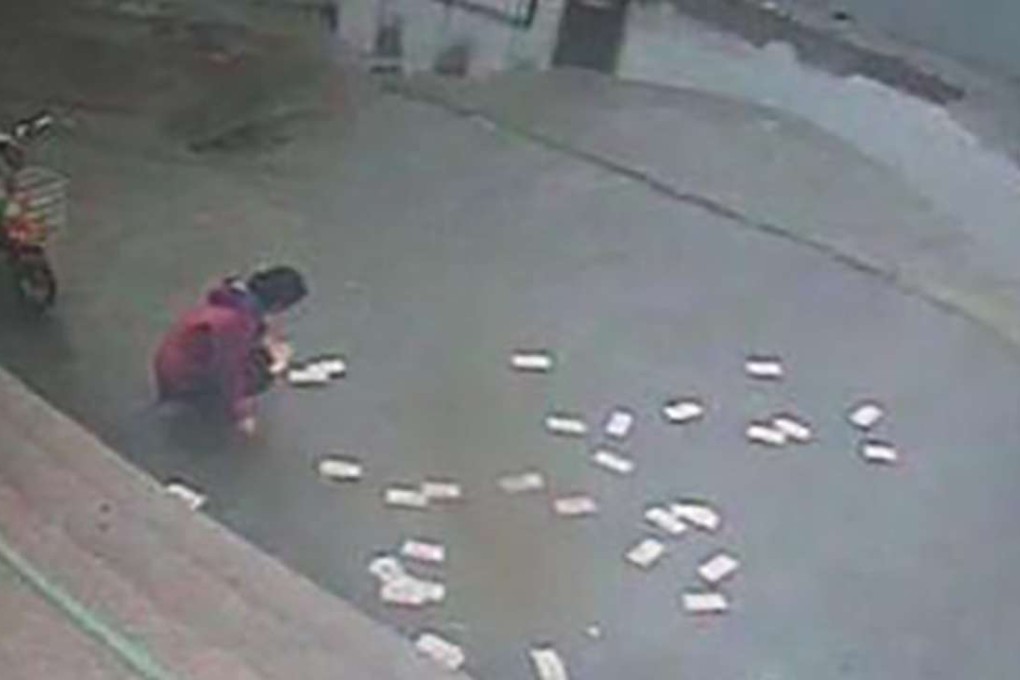 Surveillance footage shows the cash strewn across the pavement. Photo: SCMP Pictures