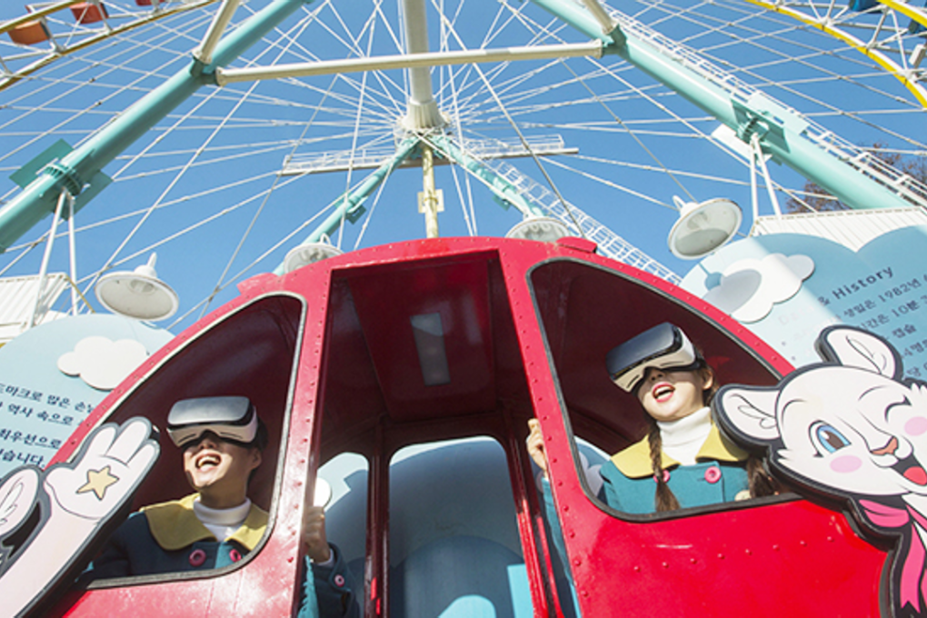 A couple wearing virtual reality (VR) goggles view a landscape as if a big wheel actually rotates at Samsung Everland, Yongin, Gyeonggi Province, Thursday. The nation's largest theme park has applied VR technologies to its suspended big wheel, enabling visitors to experience what it is like when it is in motion. Photo: Samsung Everland