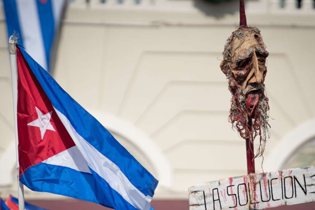 People take to the streets to react to the news of the death of former Cuban President Fidel Castro outside the restaurant Versailles November 26, 2016 in Miami, Florida. Many, mostly Cubans, gathered to wave flags and celebrate the news of the death of the Cuban revolutionary who died at 90. Photo: AFP