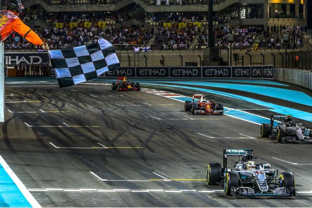 Lewis Hamilton crosses the finish line followed by Nico Rosberg in Abu Dhabi. Photo: EPA
