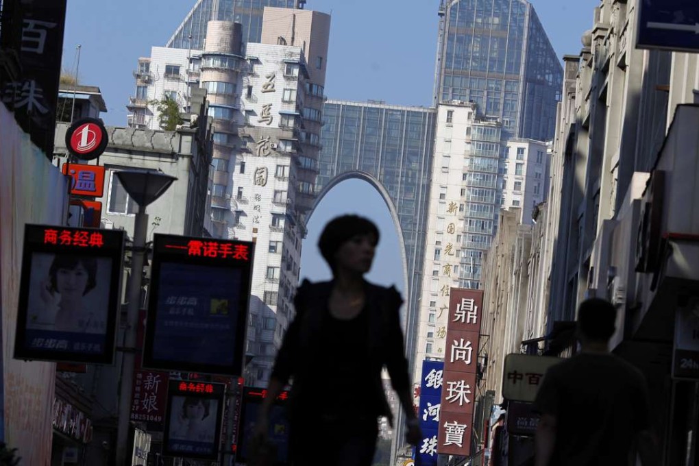 A woman walks through a commercial area in Wenzhou, Zhejiang province. The city government sparked a national outcry in April over its response to expiring residential land leases. Photo: Reuters