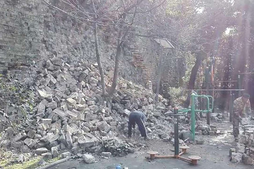 Workmen start to pick up bricks beside the ancient Nanjing City Wall, after the collapse on Sunday. Photo: SCMP Pictures