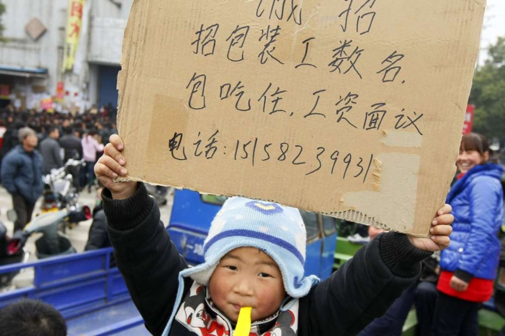 A Chinese boy holds a signboard offering employment at a labour market in Zhuji, east China's Zhejiang province. Photo: AFP