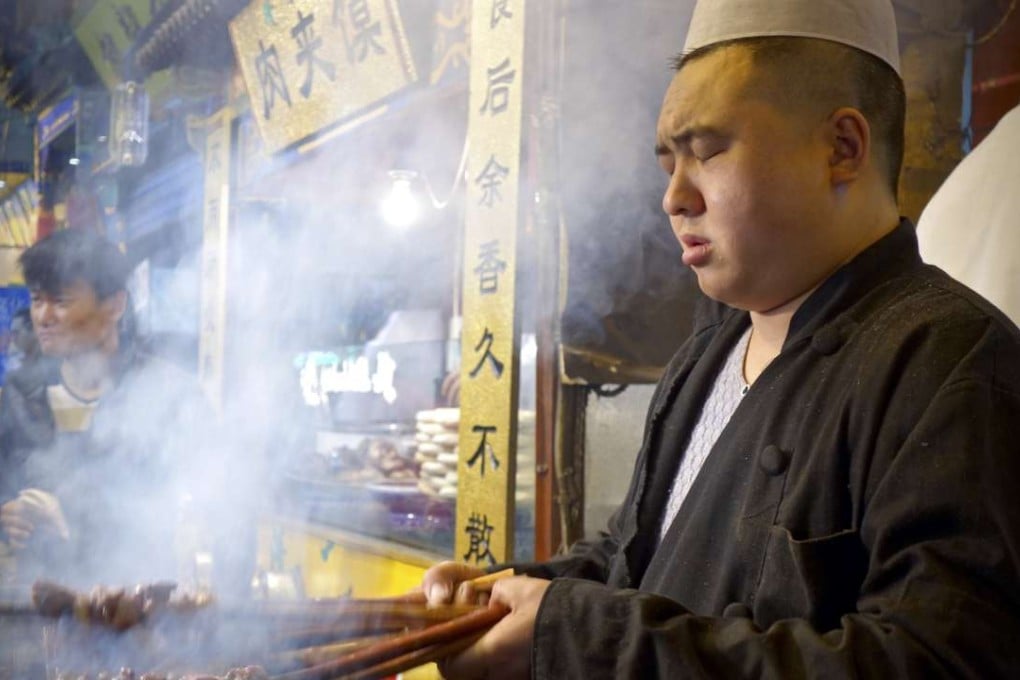A cook at work with barbecuing skewers in Xian. Photos: Juli Min