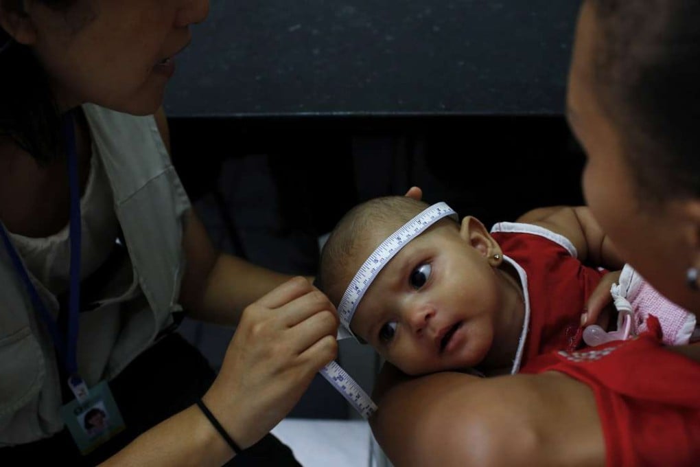 Dr. Megumi Itoh, left, an epidemic intelligence officer with the U.S. Centers for Disease Control and Prevention (CDC), measures the head of 5-month-old Adrielly Rufino, as she is held by her mother, Maria Girdielly, 17, as part of the CDC and Brazil's Ministry of Health case-control study investigating the association between women having the Zika virus when they are pregnant, and the effects they are seeing of microcephaly in babies. (Katie Falkenberg/Los Angeles Times/TNS)