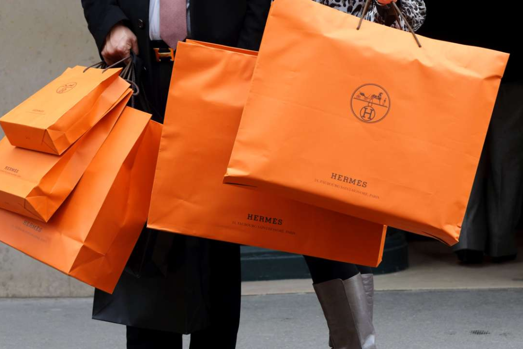 A couple walk with Hermes shopping bags as they leave a Hermes store in Paris. Photo: Reuters