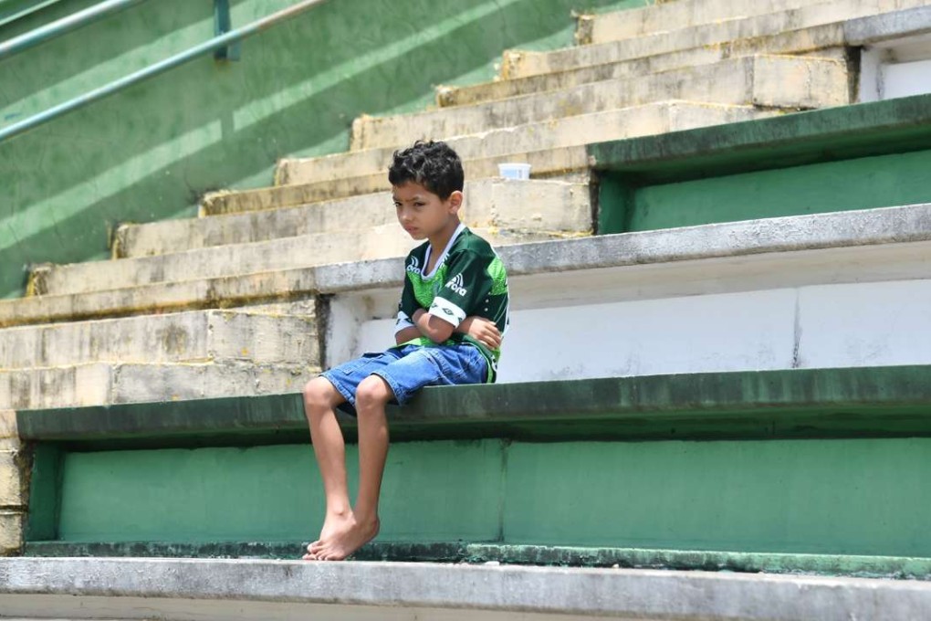 A boy sits alone on the stands during a tribute to the players and officials of Brazilian club Chapecoense Real who were killed in a plane accident in the Colombian mountains. Photo: AFP