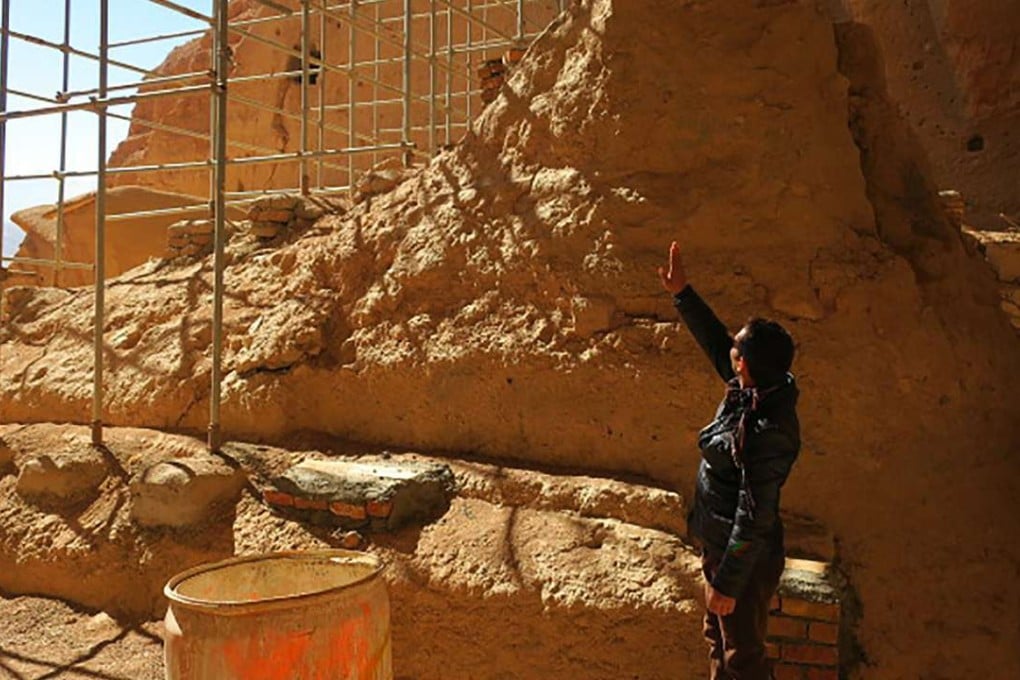 Afghan archaeological guard Hakim Safam in front of the reconstructed foot of the Salsal Buddha. Photo: AFP