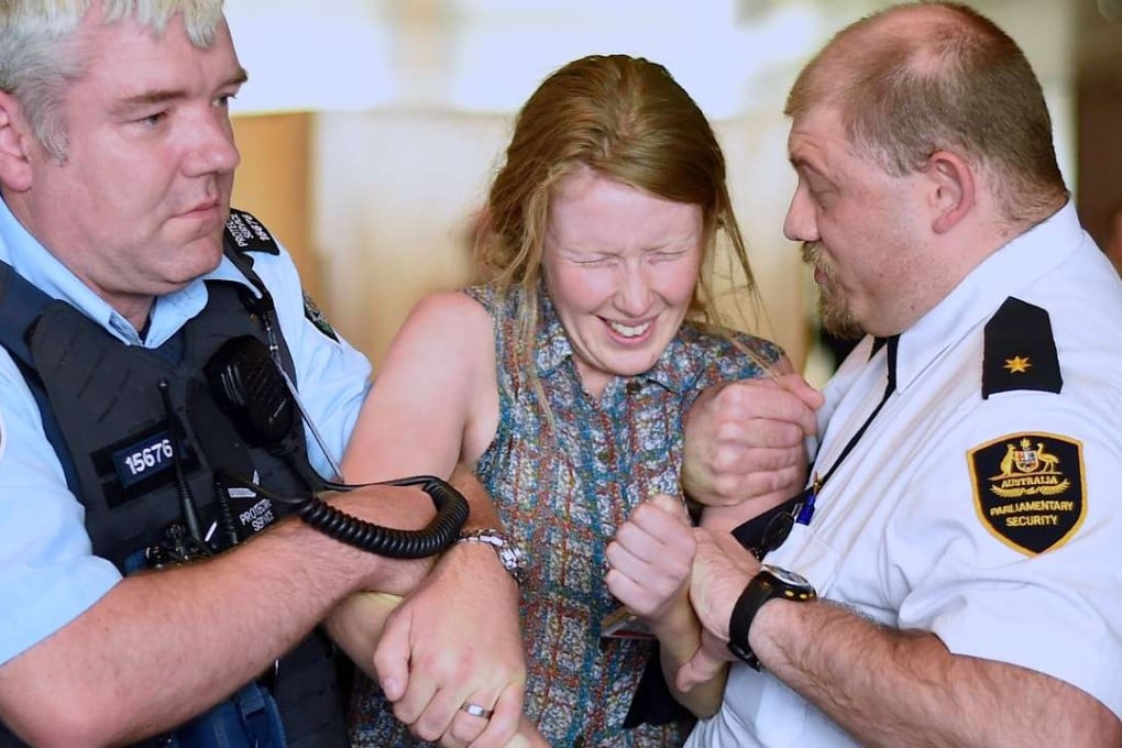 Security guards hold a protester as they remove a group from Australia’s Parliament House. Photo: Reuters