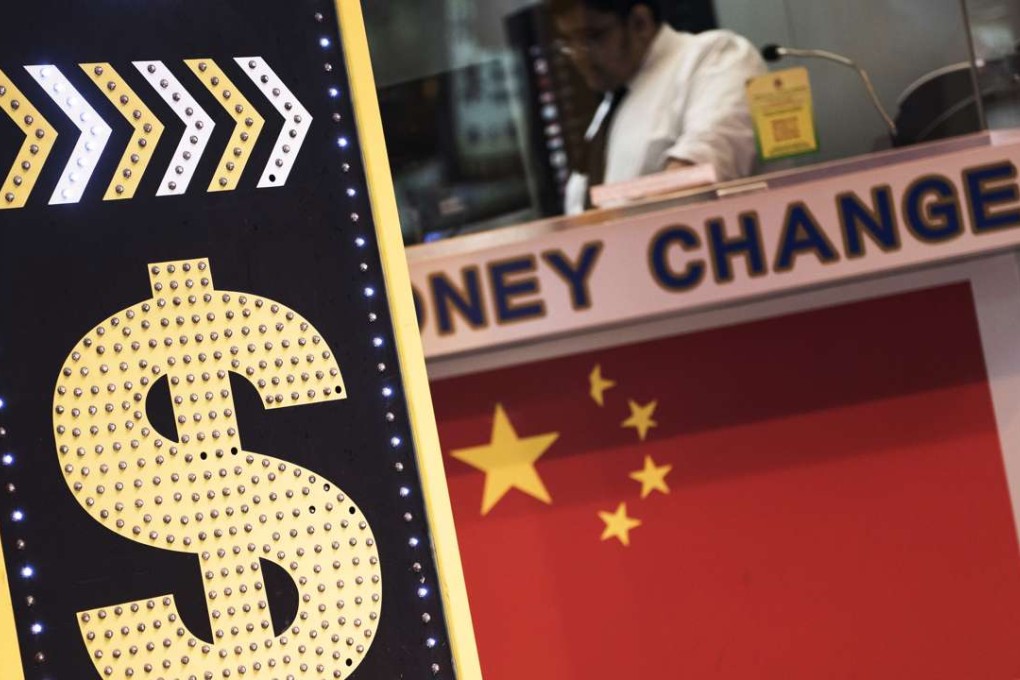 A sign displaying the Hong Kong dollar and Chinese yuan currency signs sits outside a currency exchange store in Hong Kong. Photo: Bloomberg