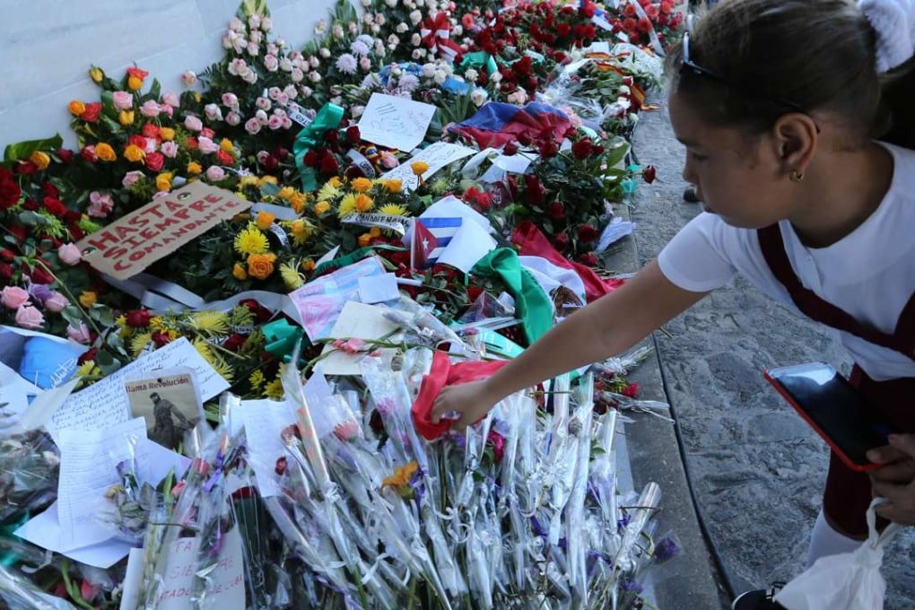 A girl lays flowers to pay tribute to Cuban revolutionary leader Fidel Castro. Photo: Xinhua