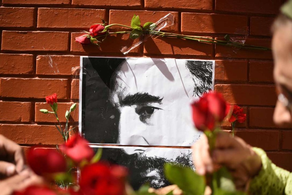 People place flowers next to a portrait of Fidel Castro outside the Cuban embassy in Guatemala City. Photo: AFP