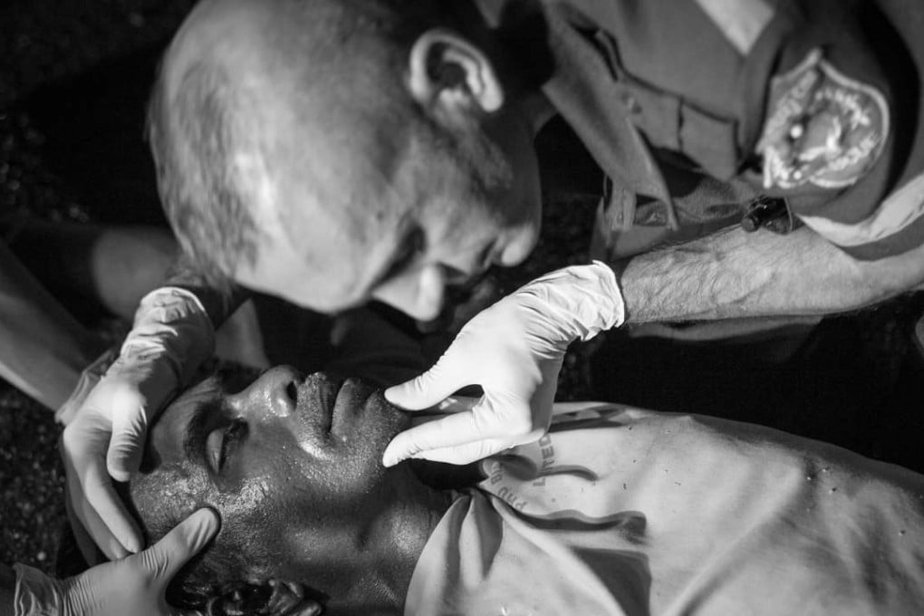 French paramedic Sébastien Perret of Vientiane Rescue assesses the injuries of one of two unconscious men whose motor-scooter crashed in Vientiane, Laos. Photos: Gary Jones