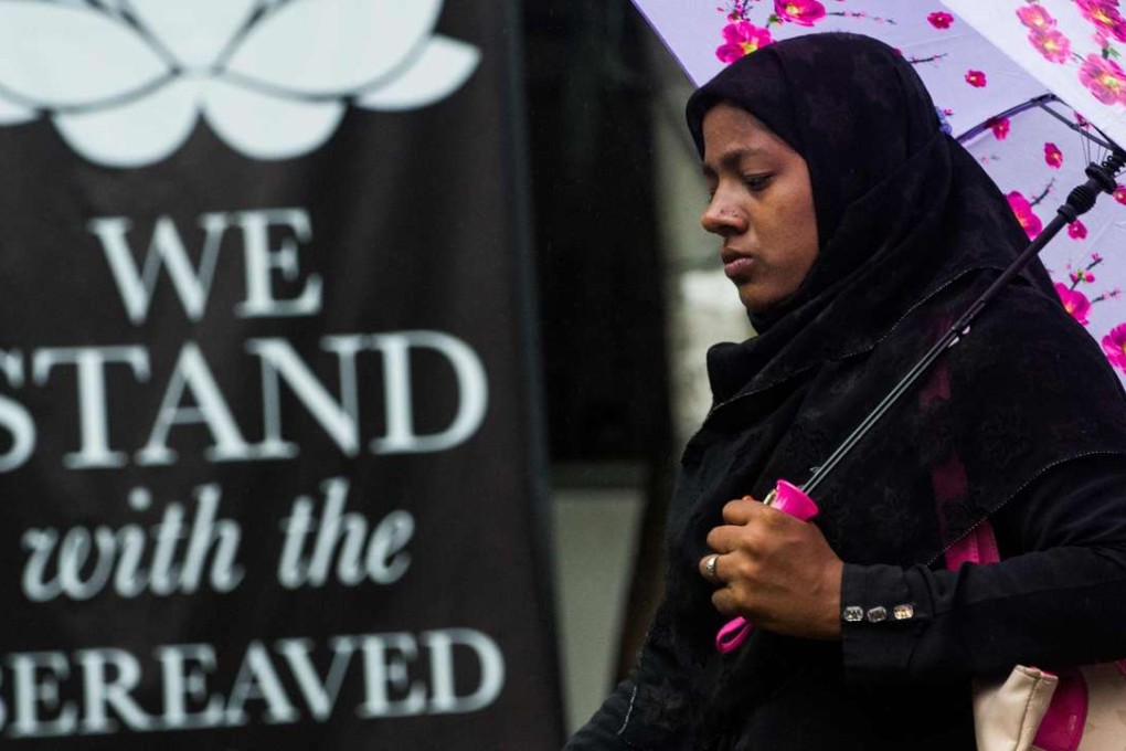 A Bangladeshi woman walks past a banner near the scene of the Dhaka siege in July. Photo: AFP