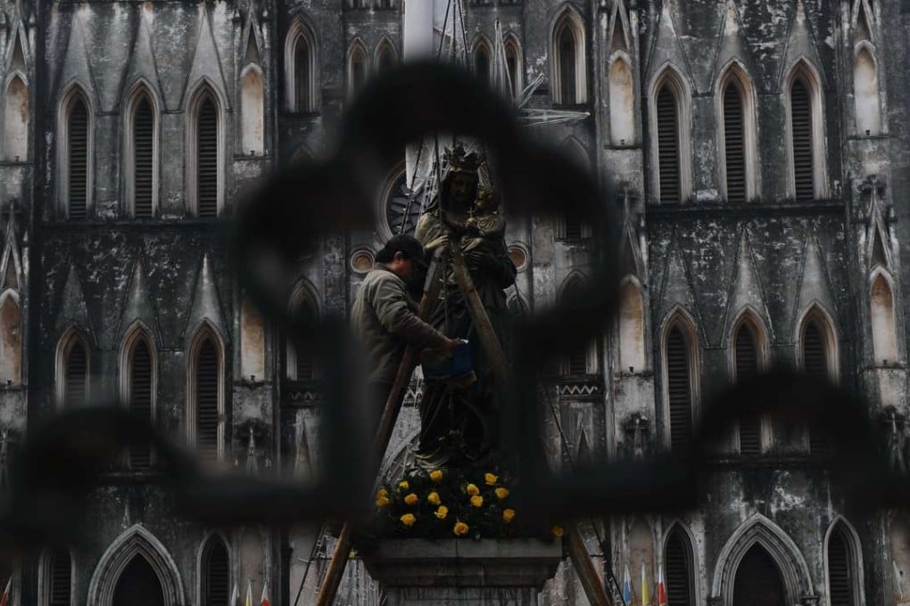 A worker polishes a statue at Hanoi’s cathedral. Hanoi recognises 39 religious organisations within 14 religions. Photo: AFP