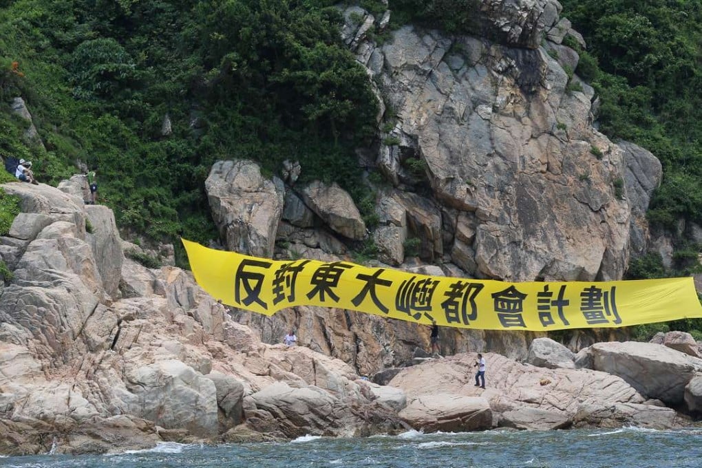 Members of Save Lantau Alliance hang a banner opposing the East Lantau Metropolis plan. Photo: K. Y. Cheng