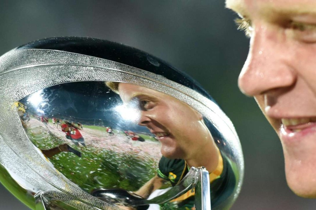 South Africa’s Dylan Sage admires the trophy after beating Fiji. Photo: AFP