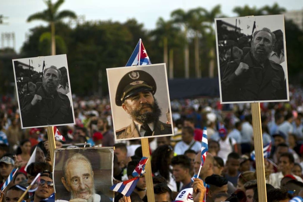 People hold pictures of the late Fidel Castro during a last homage to him at Antonio Maceo plaza in Santiago on Saturday. After a four-day journey across the country through small towns and cities where his rebel army fought its way to power nearly 60 years ago, Castro's remains arrived there, where they will be buried. (AP Photo/Ramon Espinosa)
