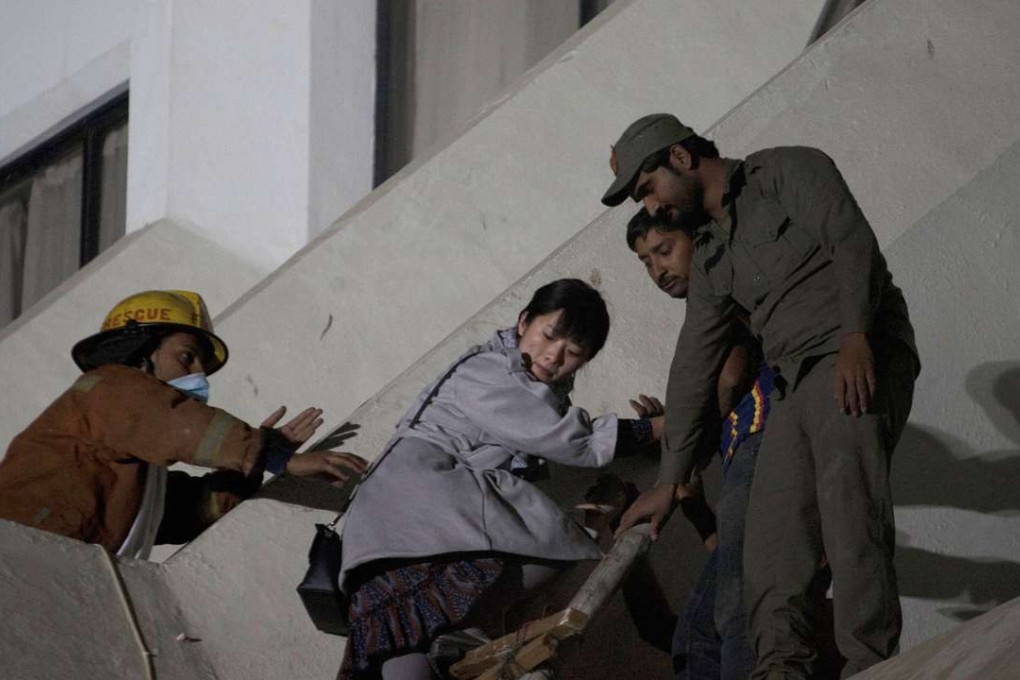 Pakistani volunteers help a foreign guest escape after a fire swept through the Regent Plaza Hotel in Karachi, Pakistan. Photo: AP