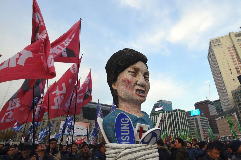 Protesters carry an effigy of South Korea’s President Park Geun-Hye during an anti-government rally demanding the resignation of the president in central Seoul. Photo: AFP