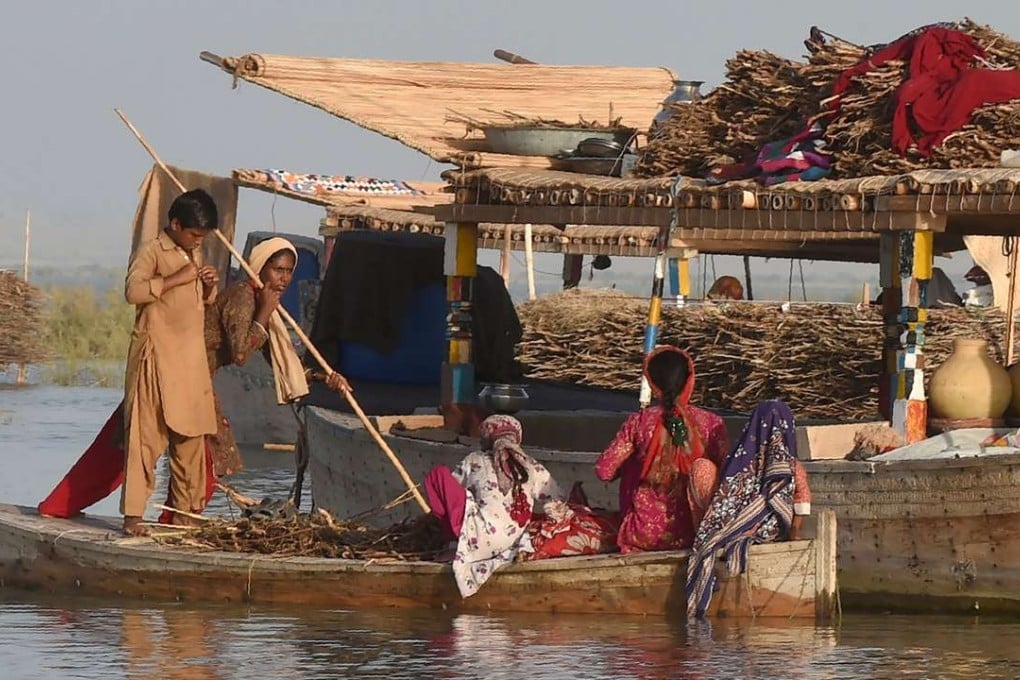 Mohanna women travel on a satellite boat to their floating boathouse on Manchar Lake. Photo: AFP