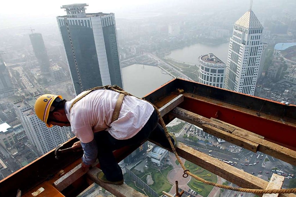 A Chinese construction worker goes about his work on a platform hanging out of a skyscraper building site in Wuhan. Photo: AFP