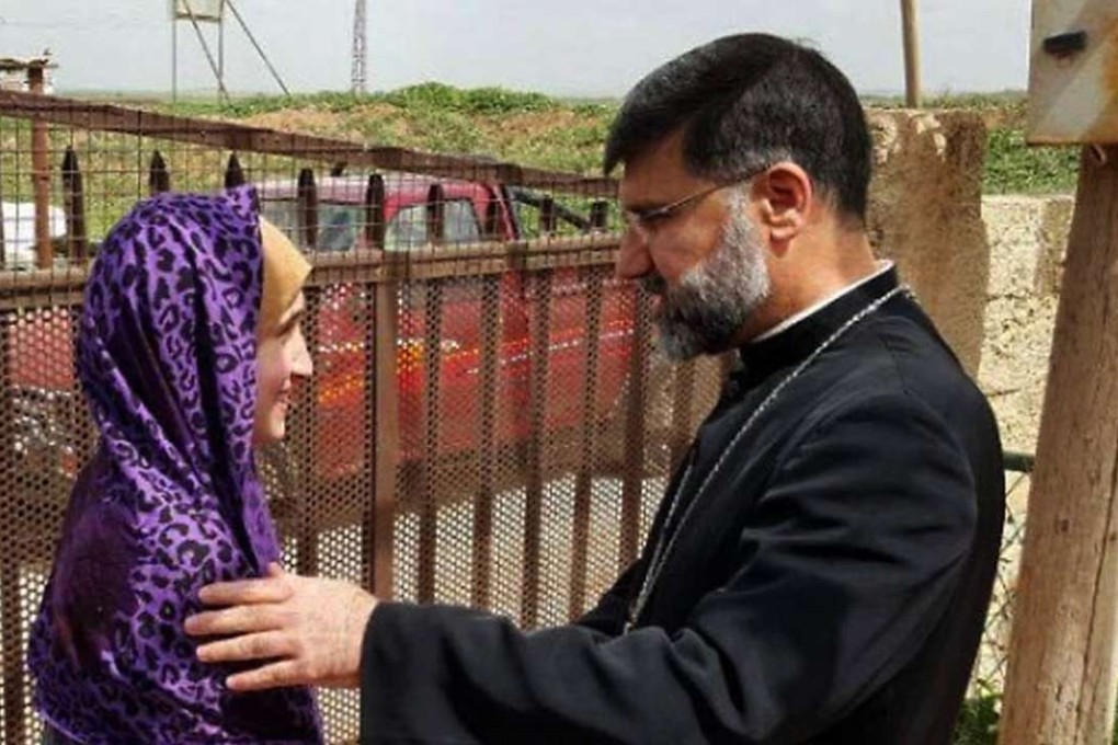 Assyrian Christian bishop Mar Afram Athneil (right) greets Maryam David Thalya after her release. Photo: AP