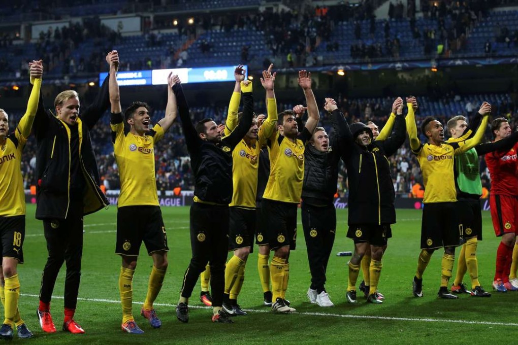 Borussia Dortmund players celebrate progressing to the last 16 in front of their travelling fans after their 2-2 draw with real Madrid. Photo: Reuters