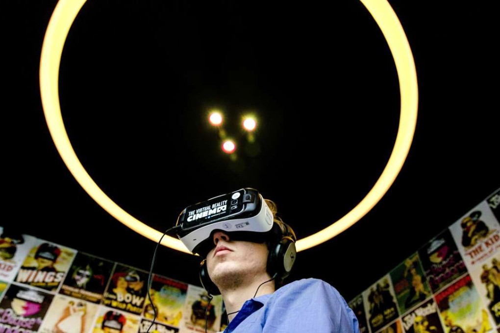 A man wearing headphones and a VR headset to watch films at the a virtual reality cinema in Amsterdam. Photo: AFP