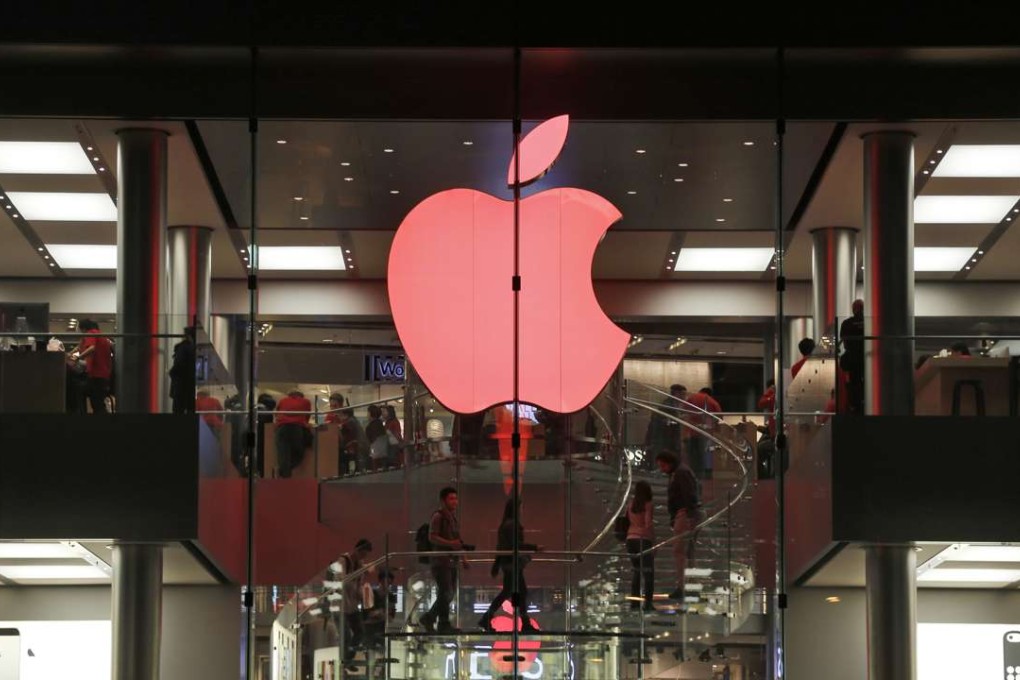 Shoppers visit the Apple store which changes its logo colour to red in support for those living with HIV in Hong Kong. Photo: AP