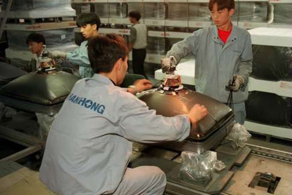 Employees of Sichuan Changhong Electronics Group Corporation work on the assembly line at the company's Mianyang factory. 10 October 1997