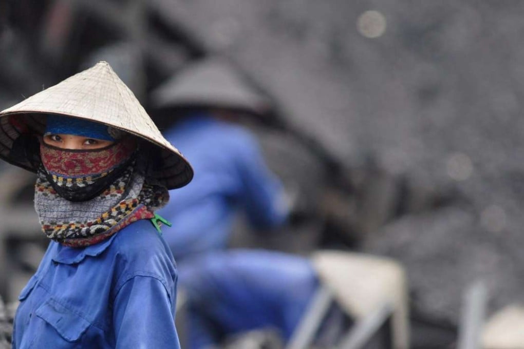 A miner takes a short break from sorting through coal at a mine in Uong Bi, northern Quang Ninh Province, Vietnam. The country has turned its back on its nuclear ambitions and has turned towards coal. Photo: EPA