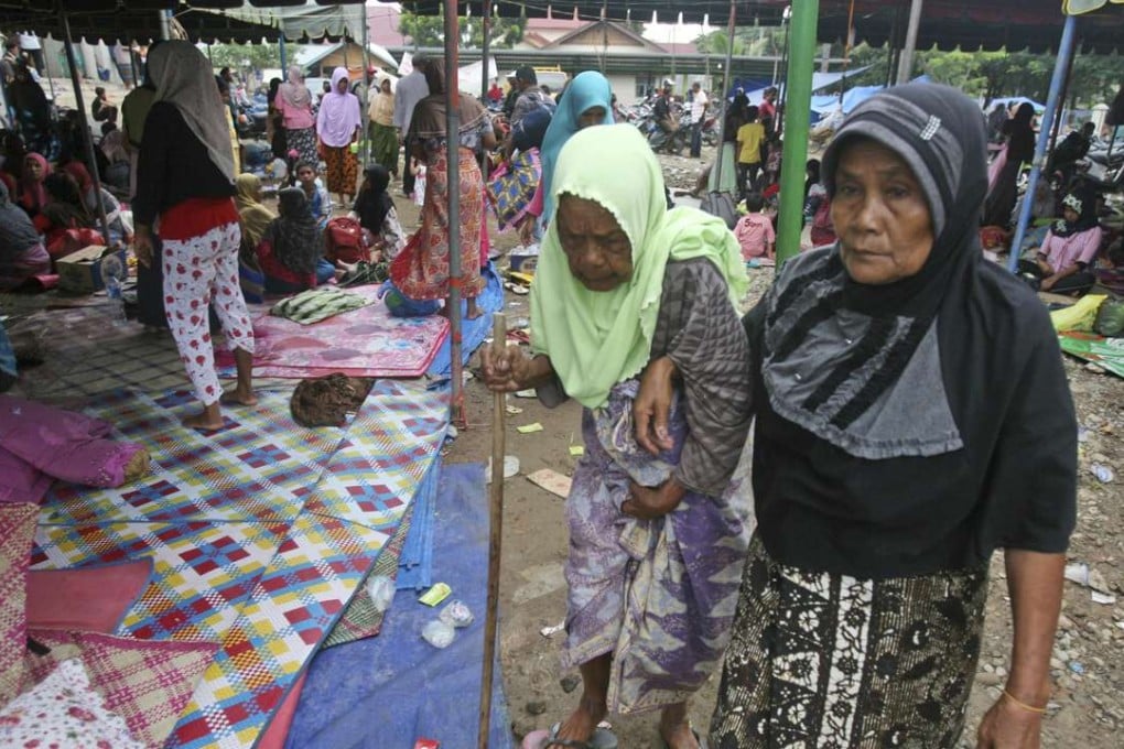 An elderly woman is assisted to a temporary shelter for people affected by Wednesday's earthquake in Ulim, Aceh. Photo: AP