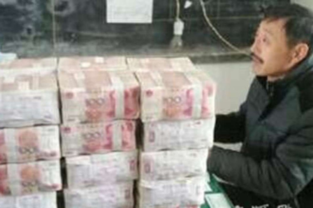The village accountant sits beside some of the cash that was returned to the farmer. Photo: News.sina.cn