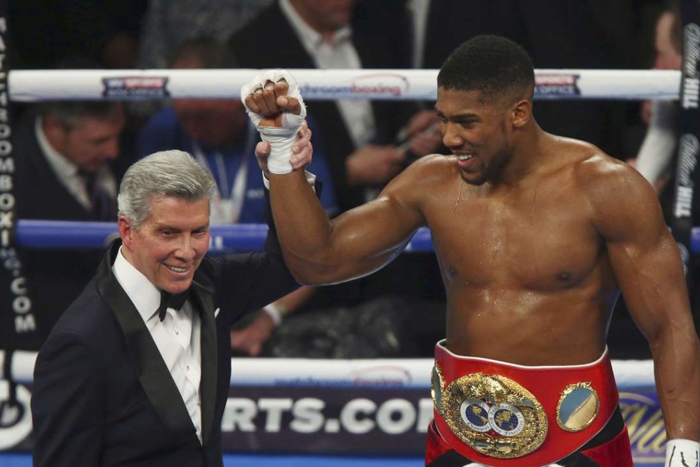 Britain’s IBF Heavyweight champion Anthony Joshua has his hand raised by ring announcer Michael Buffer after beating American Eric Molina in Manchester. Photo: AP