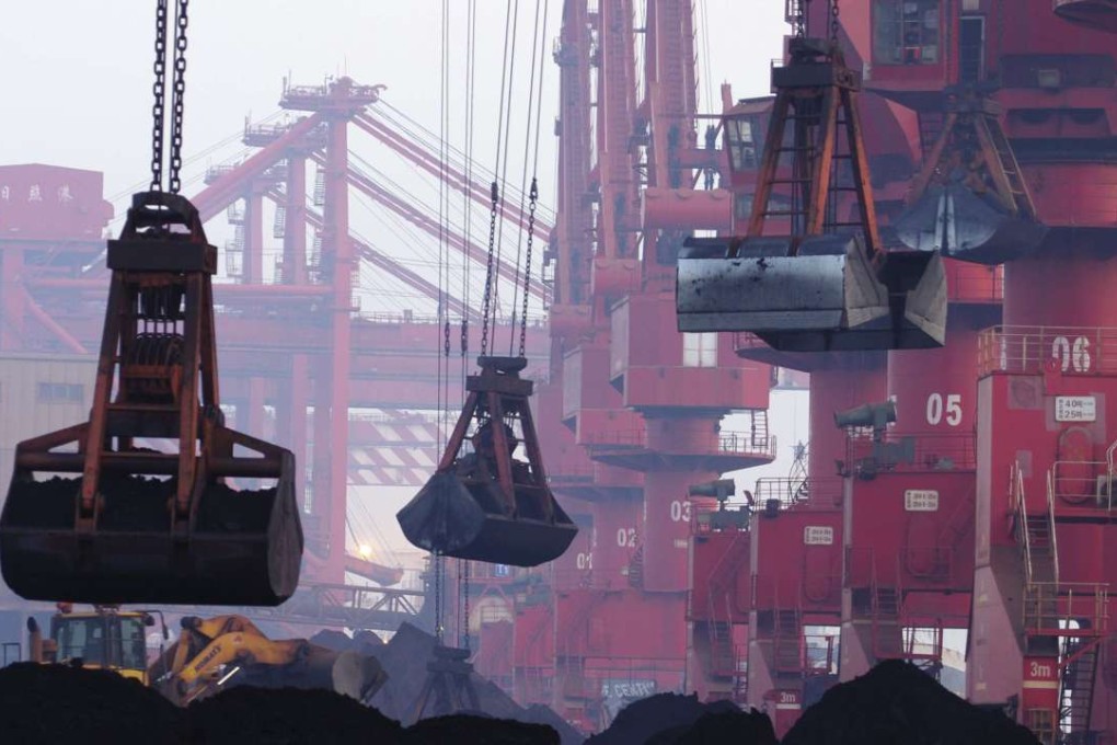Heavy machines move iron ore at the dock in Rizhao in eastern China’s Shandong province. Goldman forecasts iron ore prices to pull back to US$55 per tonne by the end of 2017. Photo: AP
