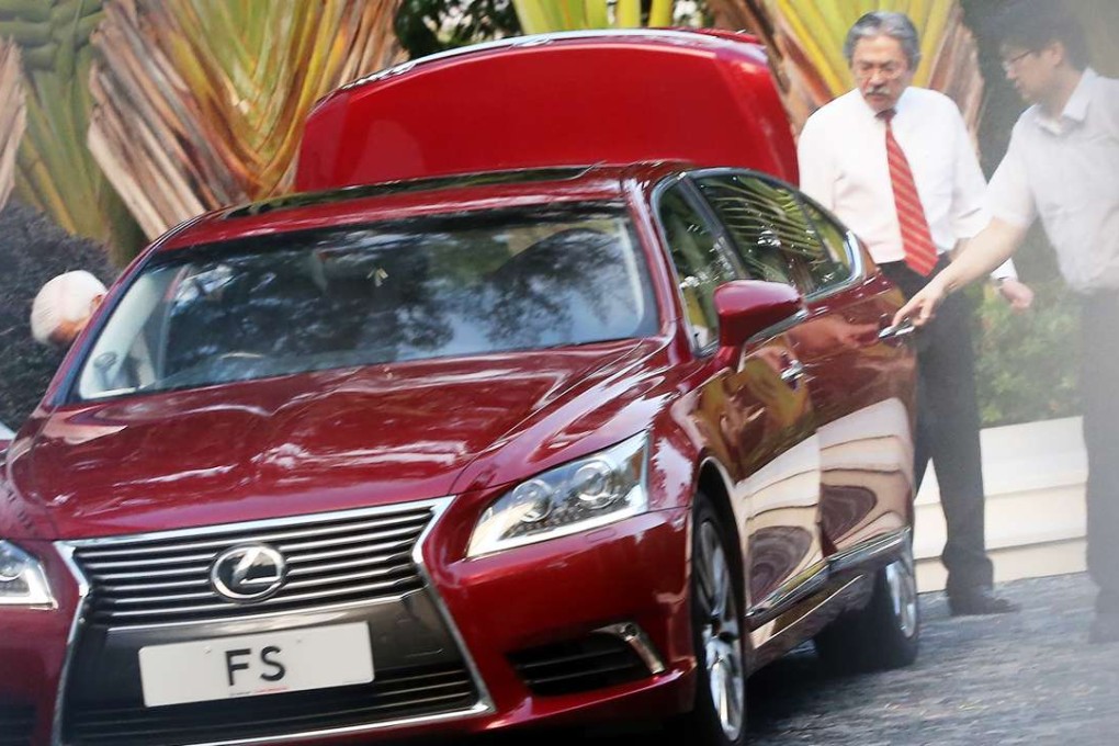 Ready to roll? Financial Secretary John Tsang Chun-wah (in red tie) leaving his home on Monday. Photo: Sam Tsang
