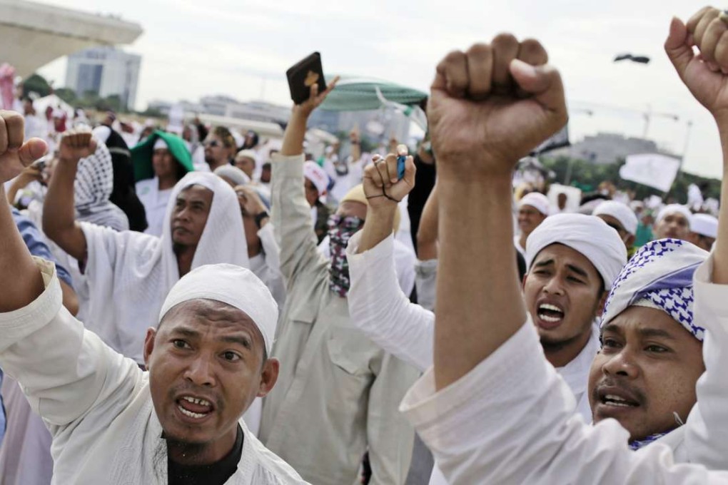 Muslim men raise their fists and shout slogans during a rally against Jakarta's minority Christian Governor Basuki "Ahok" Tjahaja Purnama. Photo: AP