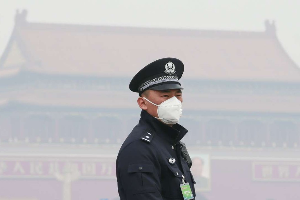 A policeman wears a mask near the Great Hall of the People in Beijing, where air pollution problems continue despite mounting efforts to control traffic and shut down coal-fired power plants and steel mills. Photo: Reuters