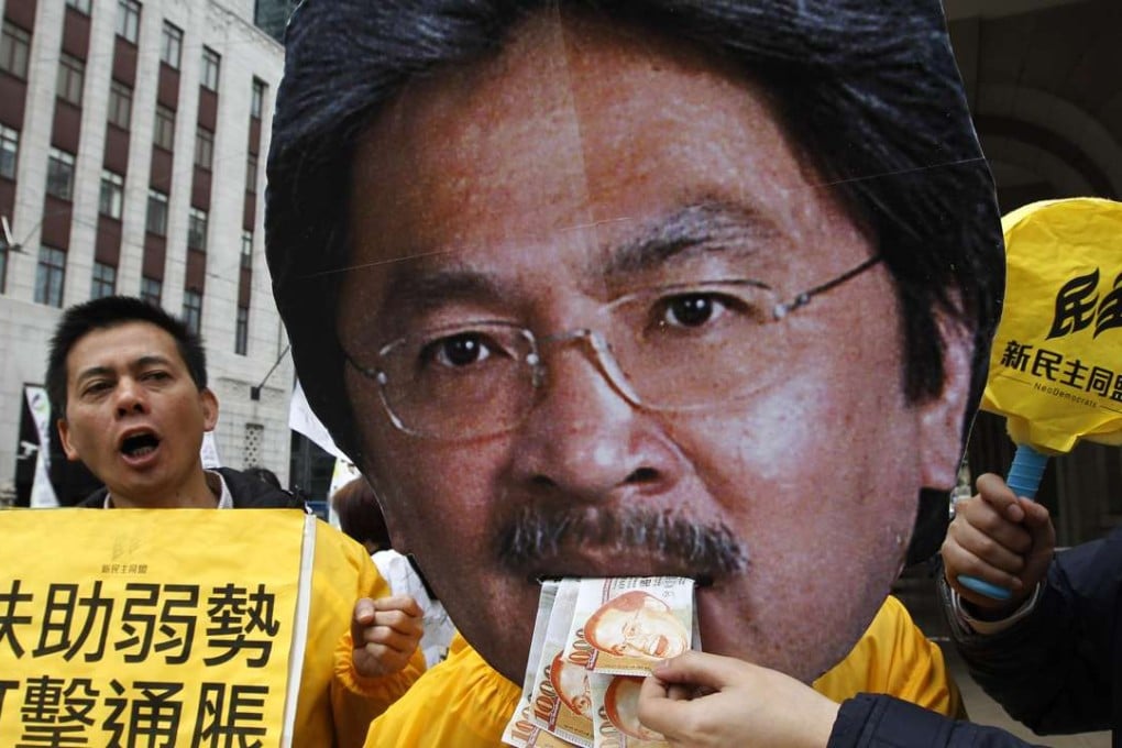 Protesters pillory Financial Secretary John Tsang in 2011 as they urge more support for the poor in his budget. Photo: AP
