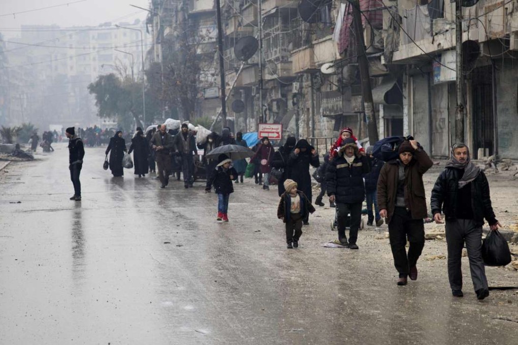 Syrians leave a rebel-held area of Aleppo towards the government-held side on Tuesday . Photo: AFP