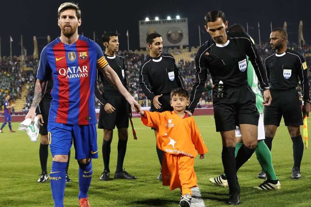 FC Barcelona Lionel Messi (L) holds the hands of Afghan boy Murtaza Ahmadi . / AFP PHOTO / KARIM JAAFAR