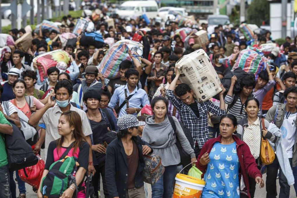 Cambodian migrant workers cross the border into Thailand. Picture: Reuters
